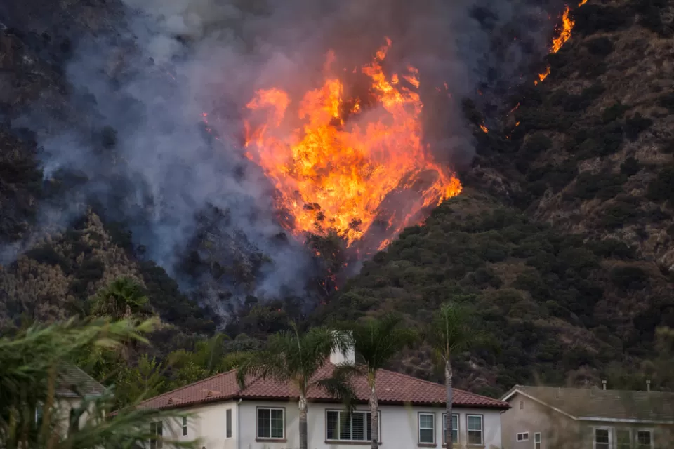 Fire burning on hillside behind house in Azusa, California